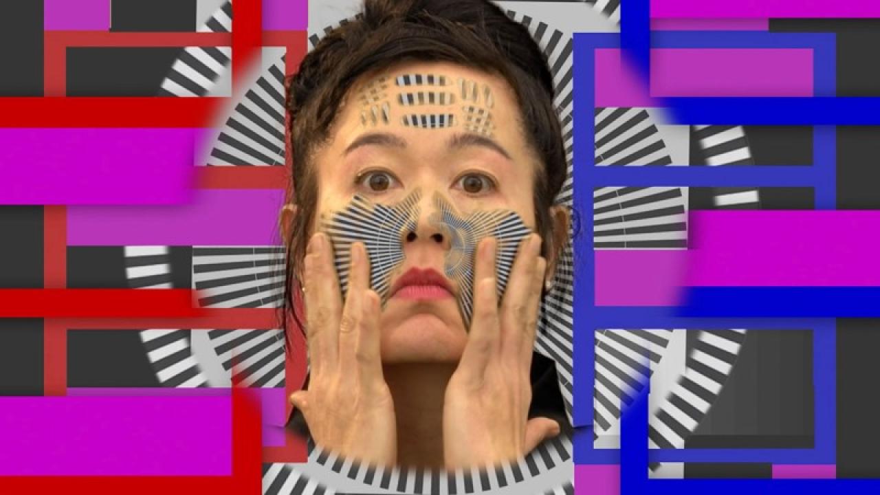 Videostandbild: Das Porträt der Künstlerin und Messfelder bilden eine abstrakt bunte Landschaft. Sachliche Lehrfilm Ästhetik trifft auf absurde, ironische Szenen.