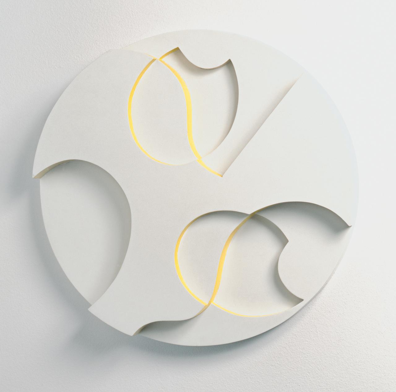 Sophie Taeuber Arp: Muscheln und Blumen, 1938, Öl auf Holz, 60x60x7,7 cm, Aargauer Kunsthaus Aarau und Gottfried Keller Stiftung, Bundesamt für Kultur, Bern - © Foto: Jörg Müller Die Farbfotografie zeigt ein weißes, rundes Relief mit gelben Farbdetails. In das Relief sind ovale Formen geprägt, welches abstrakte Blumen und Muscheln darstellen sollen.