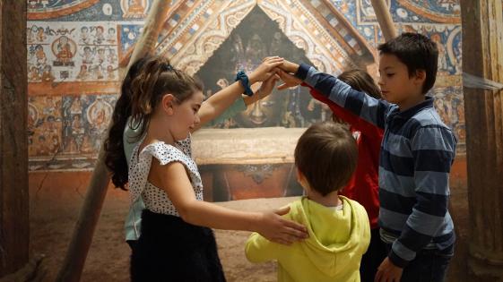 ALCHI, Gruppenarbeit, MARKK - © Museumsdienst Hamburg, Muriel Borchert Gruppe Kinder stehen Spalier vor einem Tempelbild und ein Kind geht hindurch. Teil der Sonderausstellung ALCHI Klosterjuwel im Himalaya