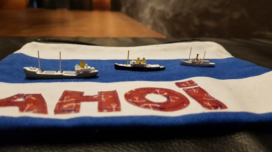 Museum zum Anfassen, Materialkoffer Internationales Maritimes Museum Hamburg - © Museumsdienst Hamburg, Ulrike Friedrichs Das Foto zeigt Objekte zum Anfassen bei der Führung: drei Wiking Miniaturmodellschiffe im Maßstab (1:1250). Es handelt sich um Küstenmotorschiffe (KüMo) im Metallguß. Mit dem Modell der Firma Wiking startete Peter Tamm seine Sammlung.