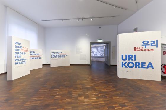 Uri Korea - ©MARKK. Fotograf: Paul Schimweg Der Eingangsbereich der Ausstellung Uri Korea Ausstellung. Auf dem Bild ist der Ausstellungstext und der Ausstellungstitel zu sehen, auf einer Wand