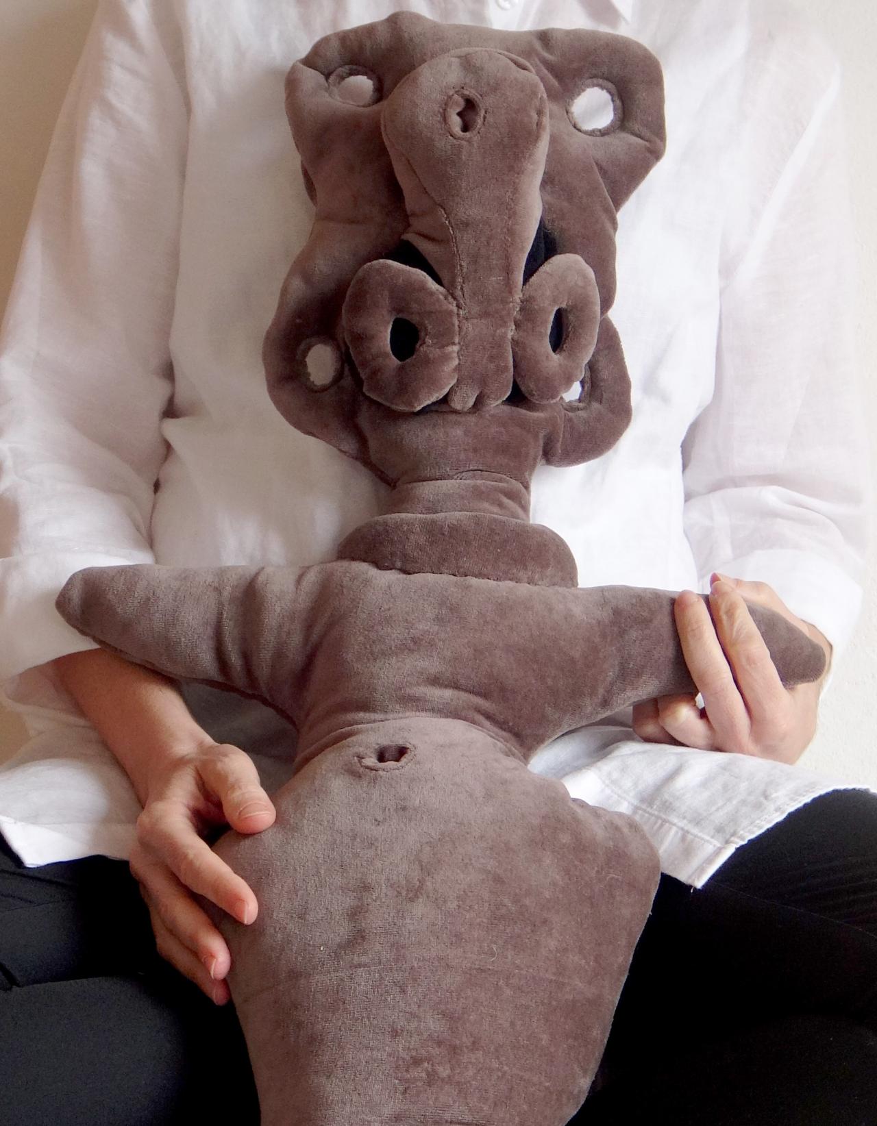 Valentina Karga, Prozessbild mit Objekt, 2022 - © Valentina Karga Auf dem Bild ist eine Person zu sehen, die eine Art Fabelwesen als Stofftier im Arm hält