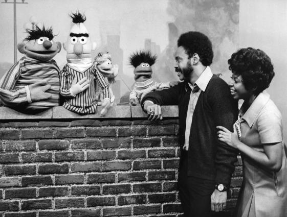 Sesame Street/Sesamstraße USA, 1969 - © Sesame Workshop. All rights reserved. Schwarz Weiß Fotografie mit zwei Afroamerikaner*innen und mehreren Puppen der Sesamstraße.
