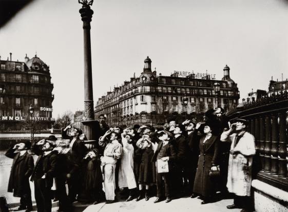 Eugène Atget, Eclipse, Paris, 1912, Sammlung Museum für Kunst und Gewerbe Hamburg - @ Eugène Atget Paris 1912 Die historische Aufnahme zeigt eine Gruppe von Menschen, die mit Ferngläsern alle in eine Richtung sehen, ohne dass die Fotografie das Motiv, das die Porträtierten ansehen, zu sehen ist