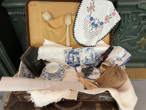 Materialkoffer Museum zum Anfassen für Menschen mit Lernschwierigkeiten im Altonaer Museum - © Museumsdienst Hamburg, Ulla Weichlein Das Foto zeigt einen Koffer voller Objekte, die man bei der Führung anfassen darf: blau weiße Porzellantasse der Marke Royal Copenhagen, Raucharoma, Stickerei, Lederriemen, Lehmbaustein mit Pfotenabdruck u.a.